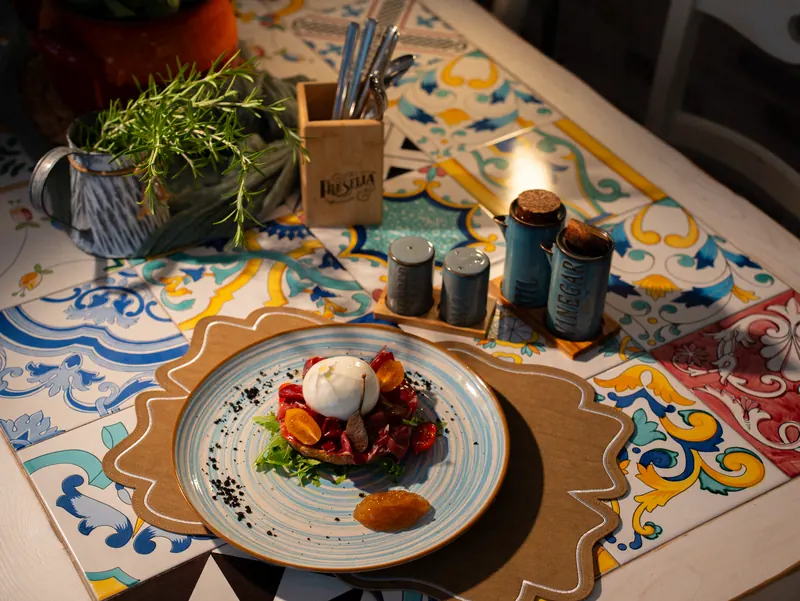 Un tavolo di Fresella con le maioliche e una fresella con burrata